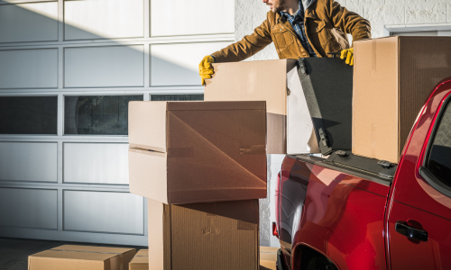 Man loading cardboard boxes in a truck bed